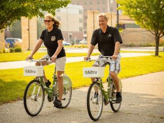 Two people riding bicycles from bike share.