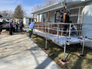 Volunteers installing ramp to house.