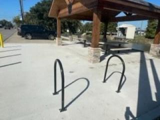 New bike rack and picnic tables under pavilion.