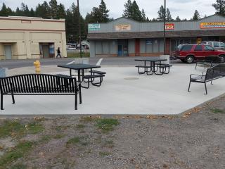 New concrete, benches, tables, and trashcans placed on plaza.