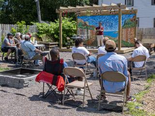 Musicians performing on stage in community garden.