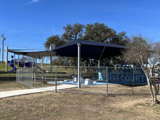 Shade structure over outdoor fitness court.
