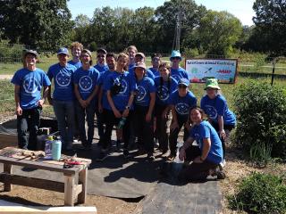 Volunteers in community garden wearing Challenge tshirts in Kansas University blue.