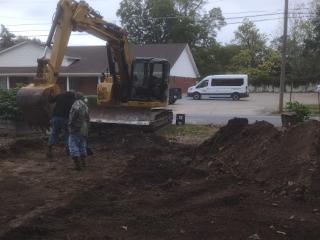 Backhoe digging new driveway.
