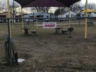 AARP sign and shade cover over picnic tables.