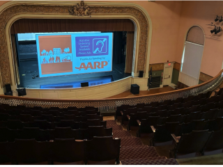 View of Claremont Opera House stage with screen describing new assistive listening devices.