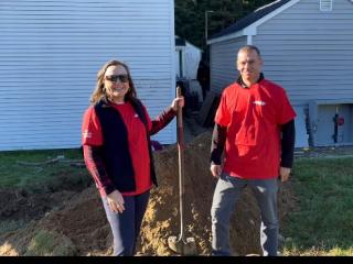 Two adults standing next to pile of dirt.