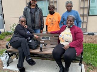Older adults sitting on new bench.