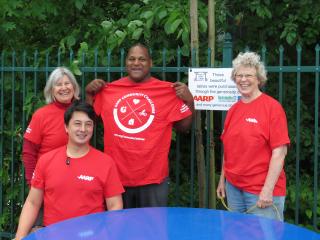 Volunteers with new picnic table and AARP sign.