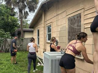 Volunteers painting house.