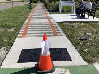 New artistic crosswalk, accessible sidewalk and bench.