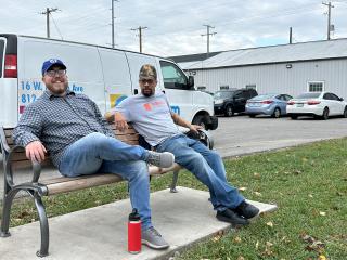 Two people sitting on new bench.