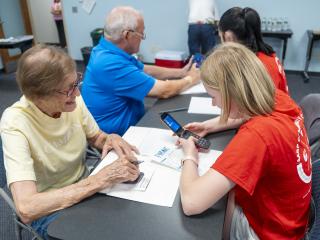 College students teaching older adults to use mobile devices.
