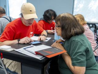 College students teaching older adults to use mobile devices.