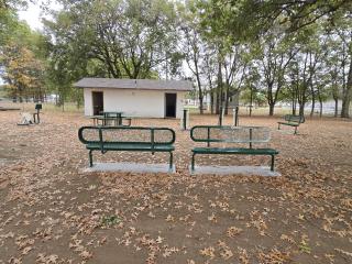 Benches, picnic table, and outdoor fitness equipment installed at park.