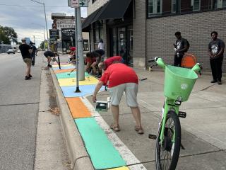 Volunteers painting sidewalk.