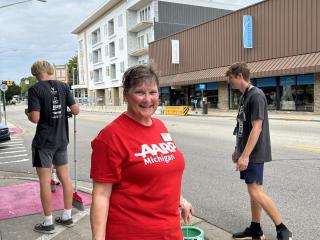 Volunteer ready to paint sidewalk.