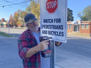 Installing pedestrian warning sign.