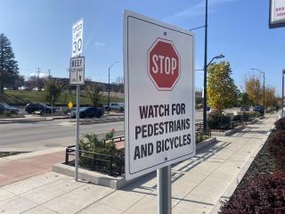 Pedestrian sign adjacent to separated walking and bike path signage.