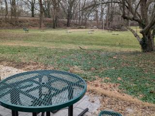 Picnic table with view of bench and apple trees.
