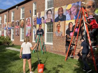 Installing photos on side of building.