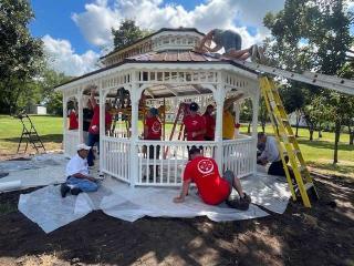 Volunteers painting gazebo.