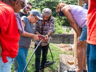 Older adults learning how to install water collection piping.