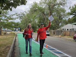 Two people walking in protected walk/bike lane.