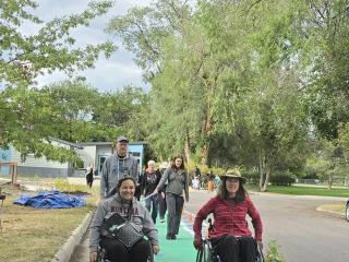 Two people in wheelchairs using protected walk/bike lane.
