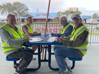 Adults sitting at picnic table completing Walk Audit worksheets.