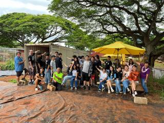 Students turning shipping container into storage for garden.