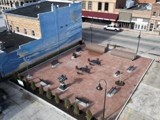 Arial view of completed plaza with mural, trees, and seating.