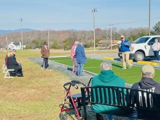 Older adults watching Bocce Ball from new bench.