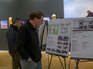 People reading posters about housing design contest.