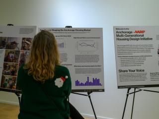 People reading posters about housing design contest.