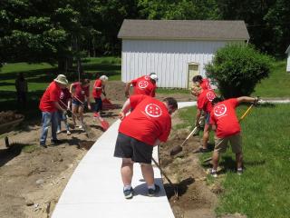 Volunteers installing landscaping adjacent to new sidewalk.