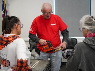 Older adults learning to use a jig saw.