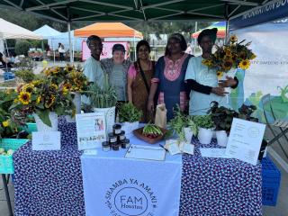 Group of farmers with table at farmers market.
