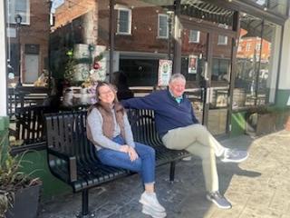 Two adults sitting on new bench.