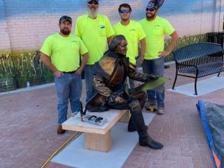 Residents next to sculpture and benches.