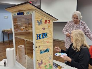 Older adult painting pantry box.