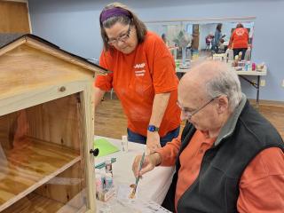 Older adult painting pantry box.