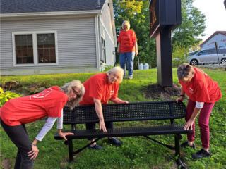 Volunteers installing new bench at library.