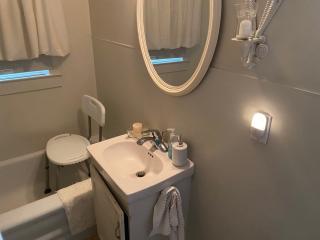 New motion sensor light and shower chair in bathroom.