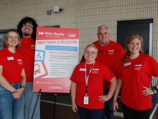 Staff next to poster about Ride Ready travel training program.