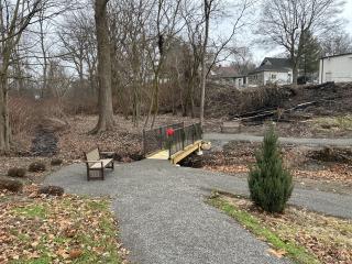 New bench, paved path, and  footbridge.