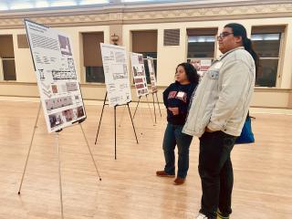 Attendees at the Design Showcase reviewing the submissions.