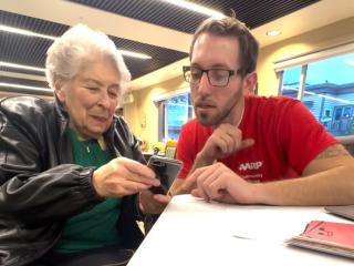 Older adult learning digital literacy skills with a smartphone.