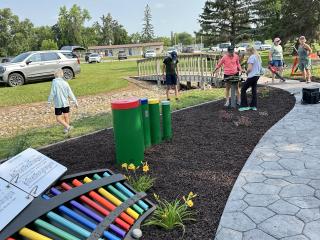 Volunteers spreading mulch around musical instruments.