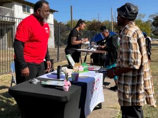 Staff speaking with community member at information fair.